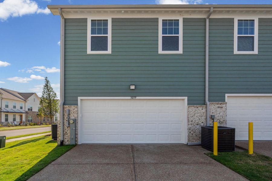 Exterior featuring horizontal siding, a white garage door, and a concrete driveway
