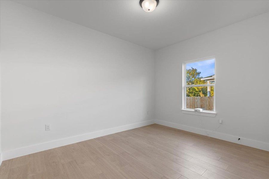 Spare room with baseboards and light wood-style flooring Spare room with baseboards and light wood-style flooring