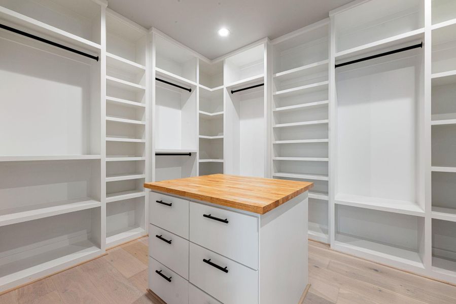 Massive custom walk-in closet with built-in island and shelving