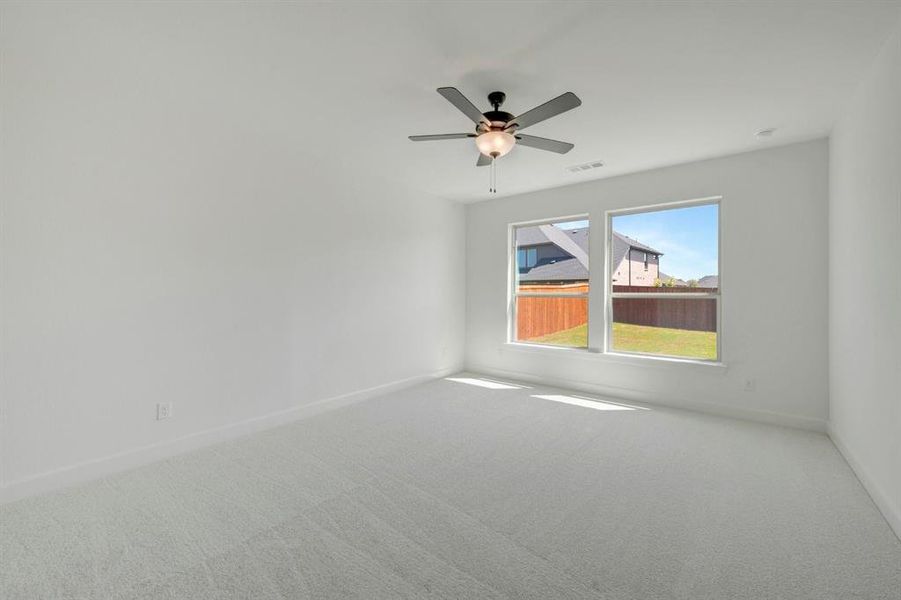 Spacious room with light gray carpeting, neutral wall finishes, and a contemporary ceiling fan with integrated lighting