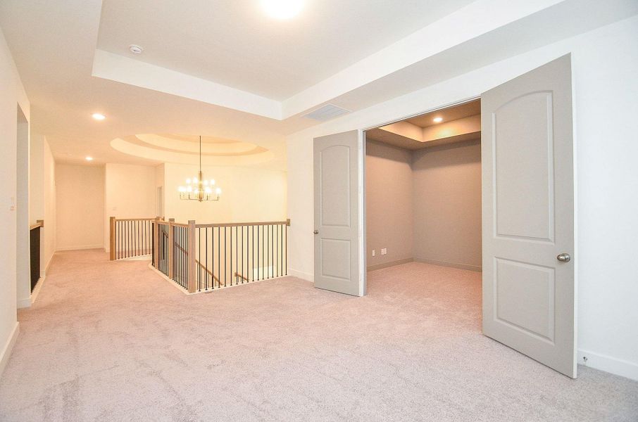 Carpeted hallway leads to the gameroom area with double-door entry to the media room.