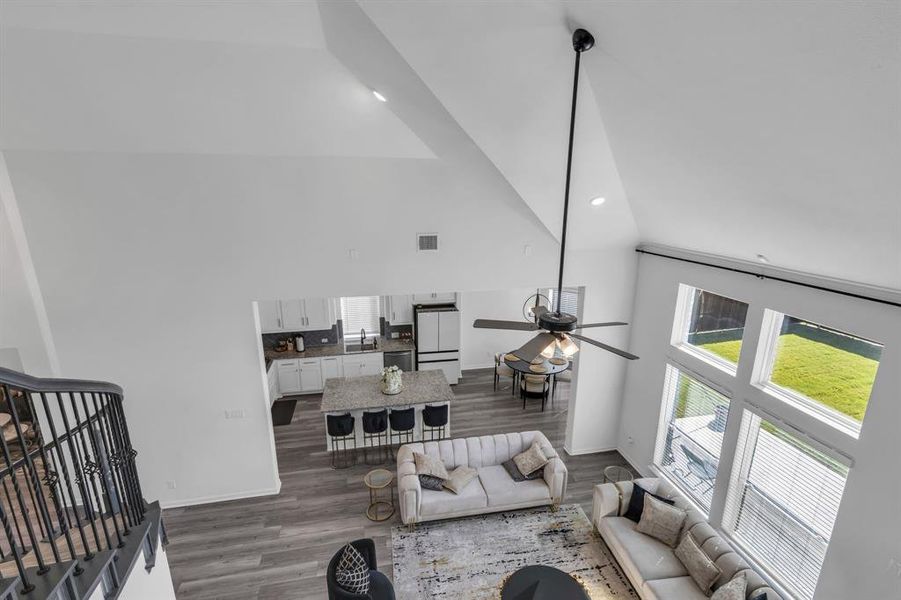 Living room featuring ceiling fan, high vaulted ceiling, dark hardwood / wood-style flooring, and sink