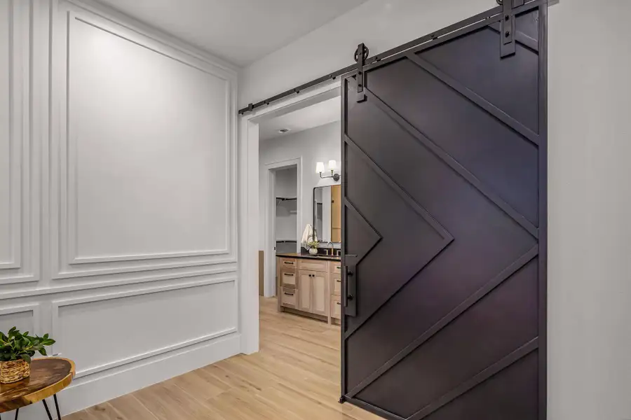 Hallway featuring a barn door, a sink, and light wood-style floors