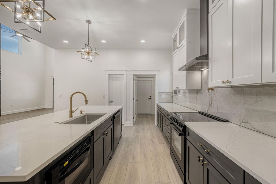 The gourmet island kitchen shines with gorgeous quartz countertops, premium built-in appliances, designer backsplash, and statement pendant lighting.
