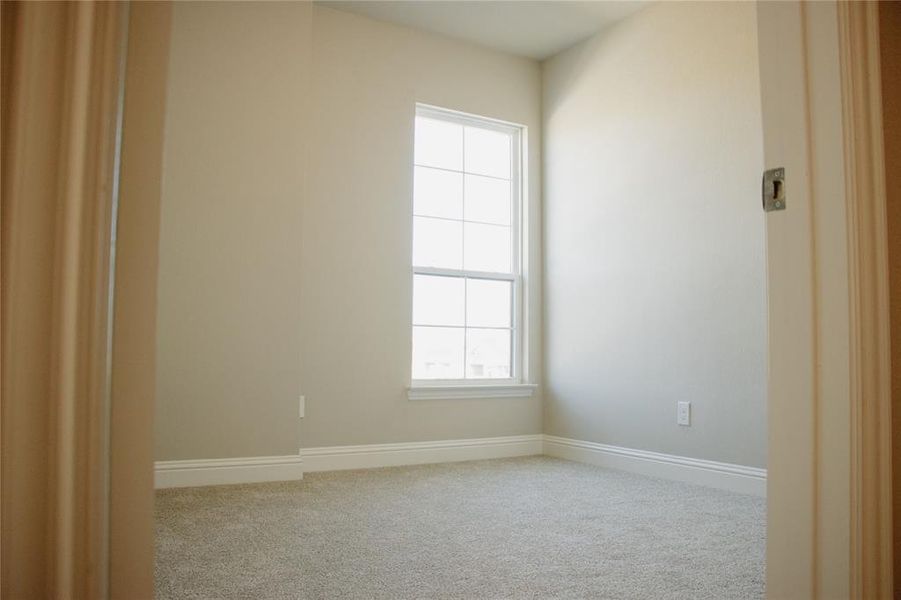 Empty room featuring light carpet