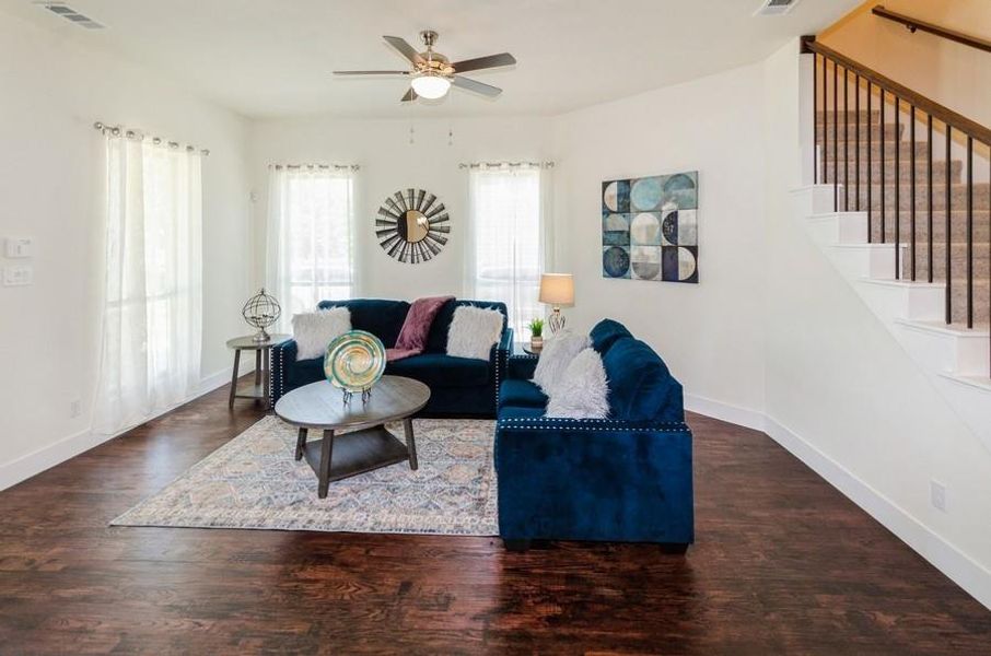 Living room with ceiling fan and dark hardwood / wood-style floors