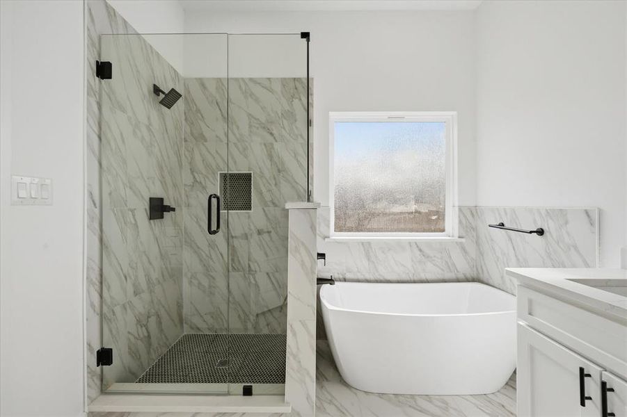 Full bathroom with vanity, marble finish floors, a freestanding bath, a marble finish shower, and wainscoting