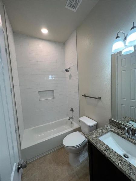 Bathroom featuring vanity, shower / washtub combination, and a textured wall