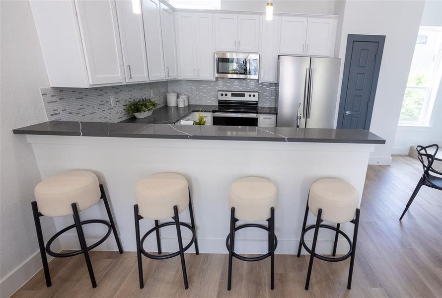 Kitchen featuring a breakfast bar, kitchen peninsula, and stainless steel appliances