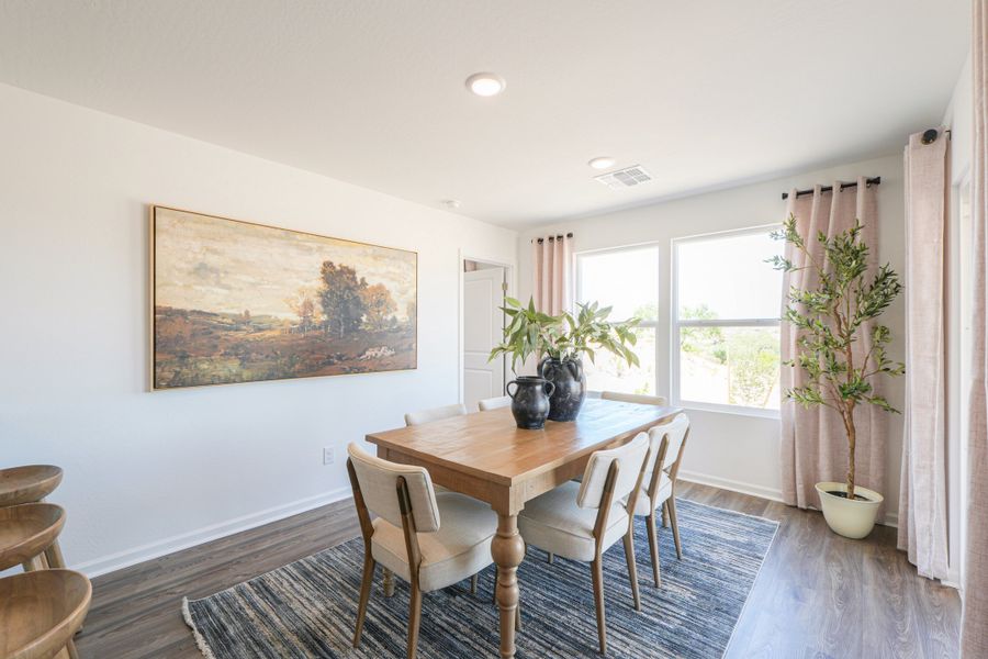 A dining room table with chairs and a painting on the wall. A dining room table with chairs and a painting on the wall.