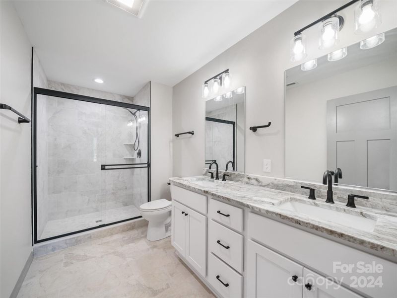 Primary Bath on Upper level with tiled floor and shower double vanity sinks, raised height toilets and beautiful tiled floor and shower Primary Bath on Upper level with tiled floor and shower double vanity sinks, raised height toilets and beautiful tiled floor and shower