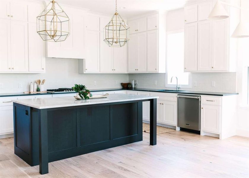 Kitchen with light wood-type flooring, a chandelier, decorative light fixtures, and stainless steel dishwasher