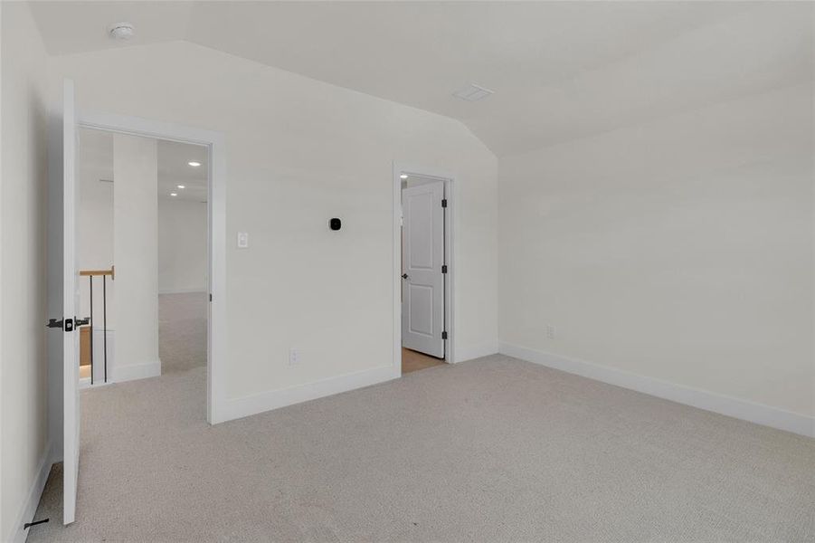 Carpeted room with white walls, baseboards, and two doorways