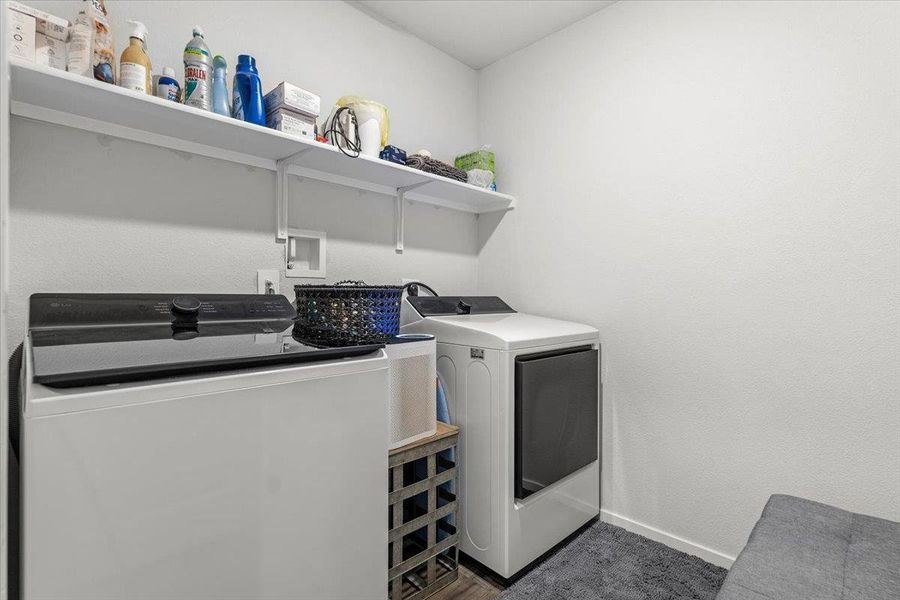 Laundry area with separate washer and dryer and baseboards