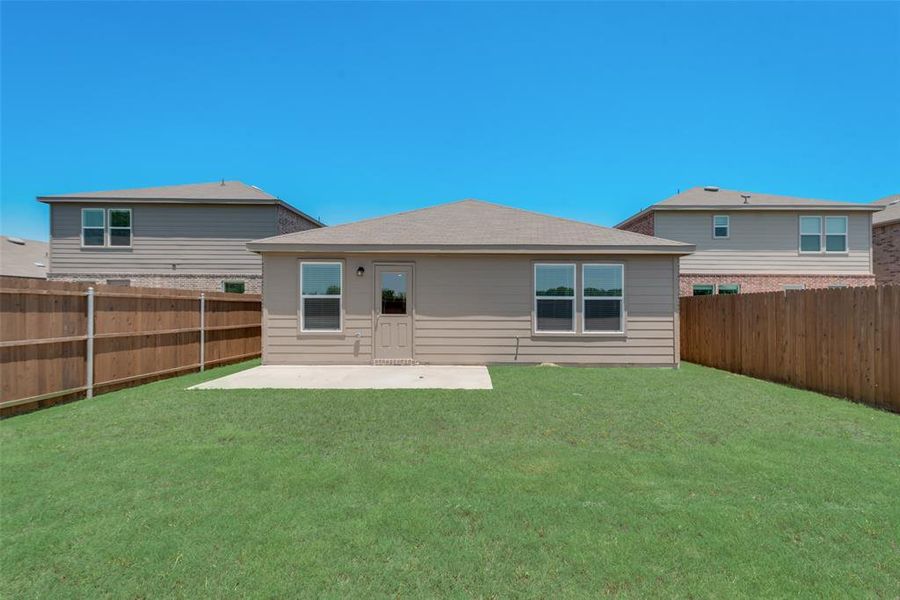 Back of property featuring a lawn and a patio