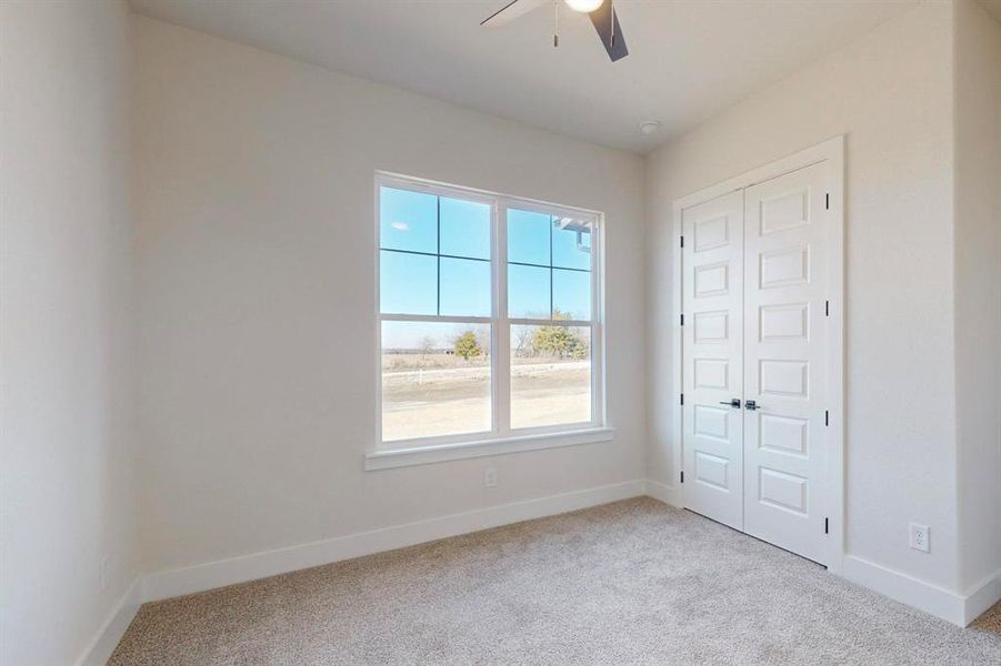 Unfurnished bedroom with multiple windows, light colored carpet, a closet, and ceiling fan