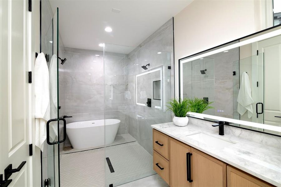 Bathroom with tile patterned flooring, vanity, tile walls, and shower with separate bathtub