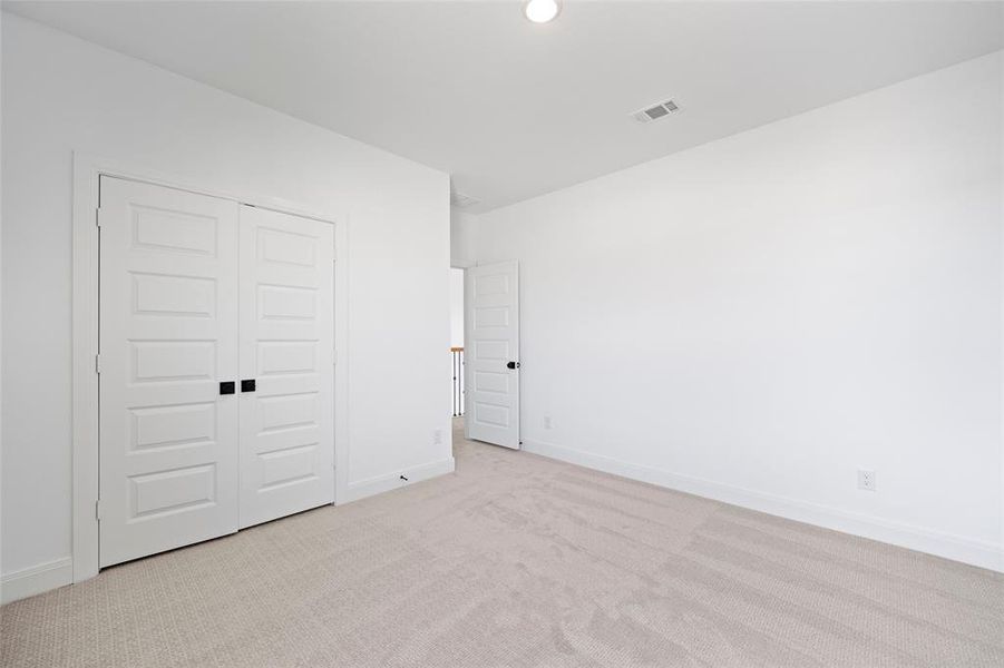 Unfurnished bedroom featuring light colored carpet and a closet