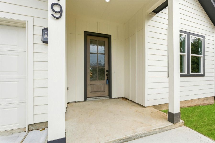 Spacious front porch with a gorgeous, solid wood door. Spacious front porch with a gorgeous, solid wood door.