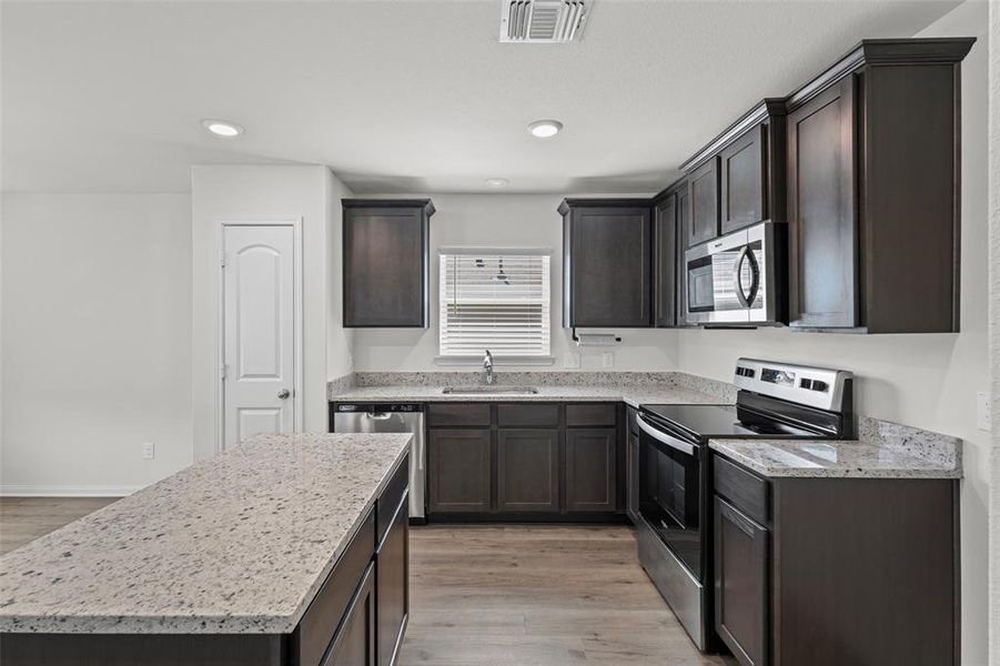 Kitchen with granite counters, island and so many cabinets