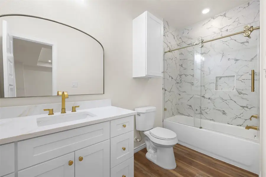 Bathroom featuring combined bath / shower with glass door, dark wood-style floors, vanity, and recessed lighting Bathroom featuring combined bath / shower with glass door, dark wood-style floors, vanity, and recessed lighting