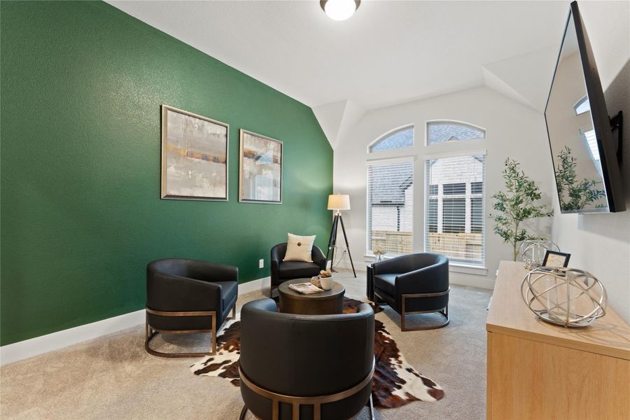 Vaulted ceiling room featuring an arched window, textured green accent wall, and neutral carpeting