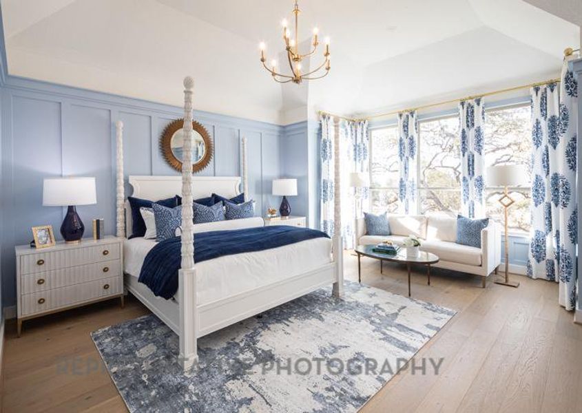 Bedroom featuring a decorative wall, an inviting chandelier, and wood finished floors Bedroom featuring a decorative wall, an inviting chandelier, and wood finished floors