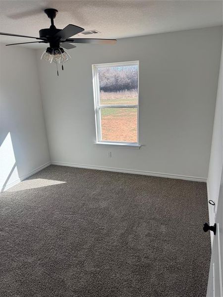 Carpeted empty room with ceiling fan