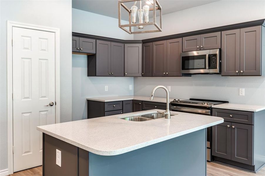 Kitchen featuring light hardwood / wood-style floors, sink, a center island with sink, and stainless steel appliances