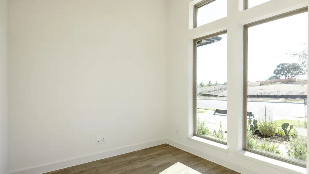 Spare room featuring dark wood-style flooring and a water view