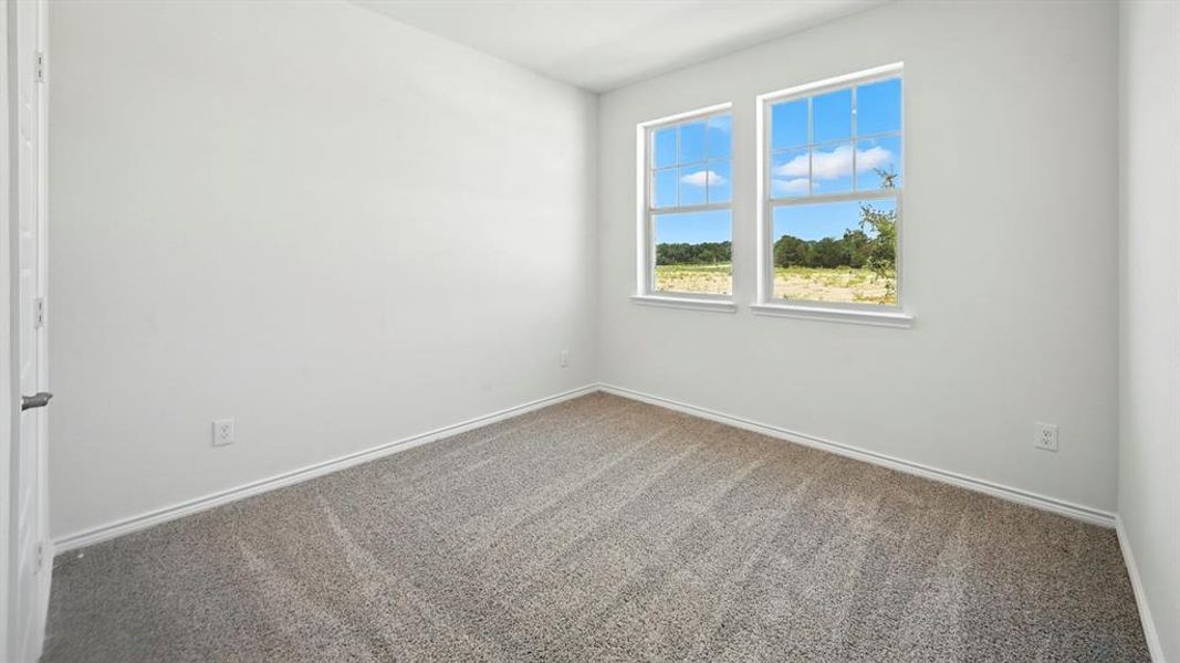 Bright room featuring two double-hung windows with white trim, gray speckled carpeting, and white baseboards