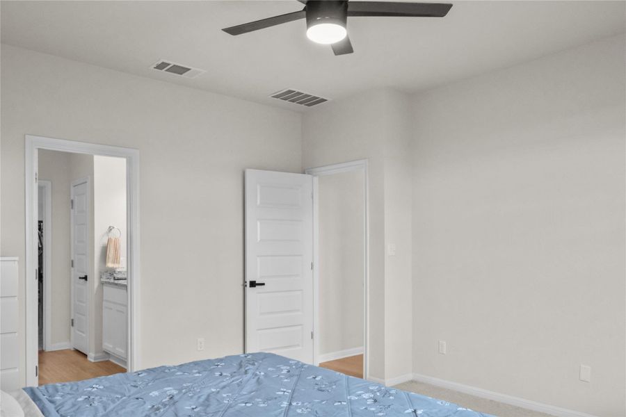 Bedroom with a ceiling fan and ensuite bath