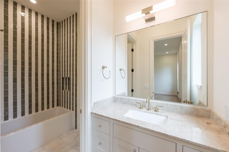 This is a true separate Jack and Jill bathroom, offering private vanities on each side with a shared wet area in between. The bold vertical tile design and elegant finishes provide style and function for shared living without compromise. This is a true separate Jack and Jill bathroom, offering private vanities on each side with a shared wet area in between. The bold vertical tile design and elegant finishes provide style and function for shared living without compromise.