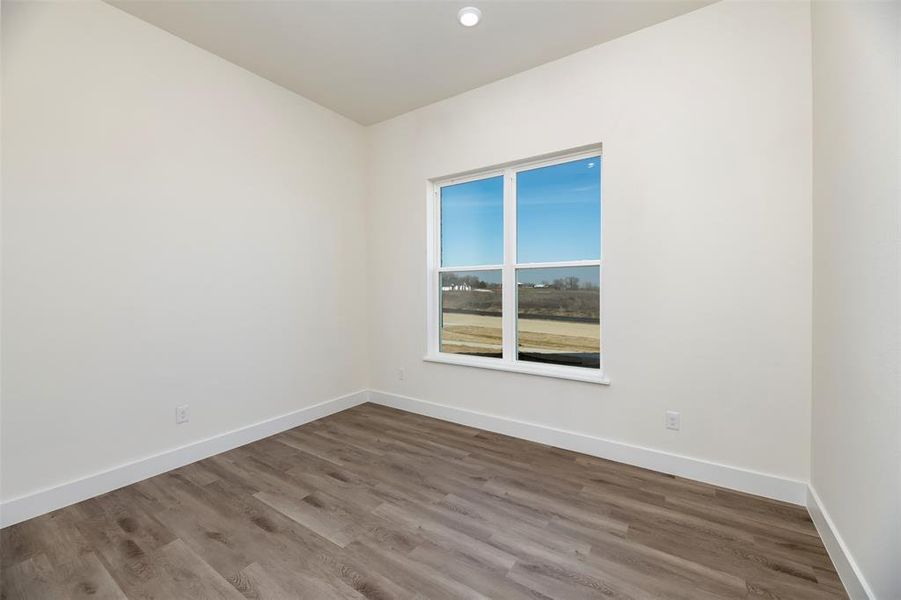 Spare room featuring baseboards and wood finished floors