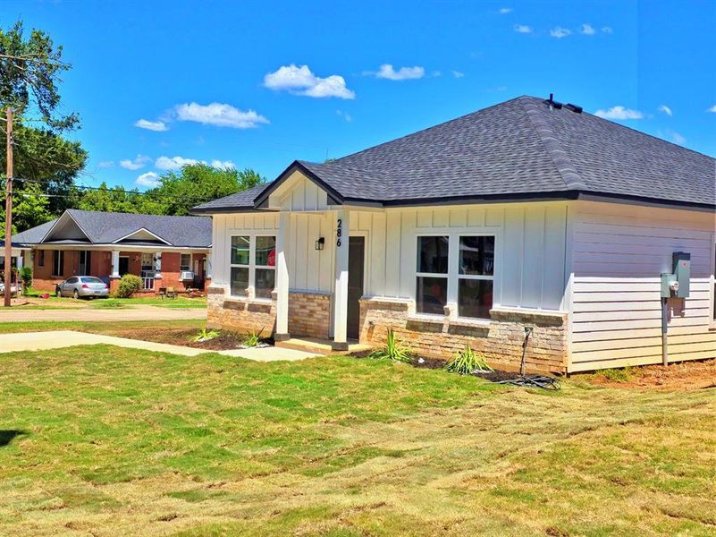 View of front of house featuring a front lawn, board and batten siding, a porch, and a shingled roof View of front of house featuring a front lawn, board and batten siding, a porch, and a shingled roof