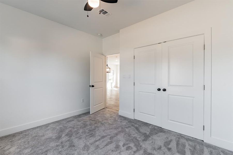 Unfurnished bedroom with light colored carpet, a closet, and ceiling fan