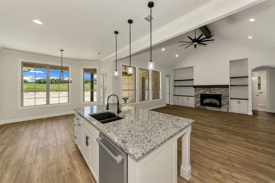Kitchen featuring stainless steel dishwasher, wood finished floors, white cabinets, a center island with sink, and recessed lighting