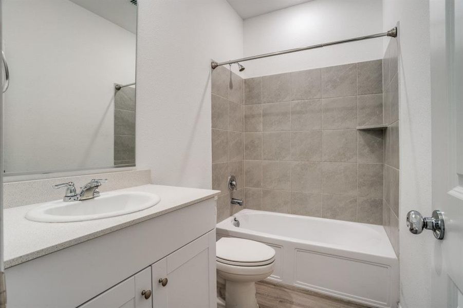 Full bath with vanity, tub / shower combination, and light wood finished floors