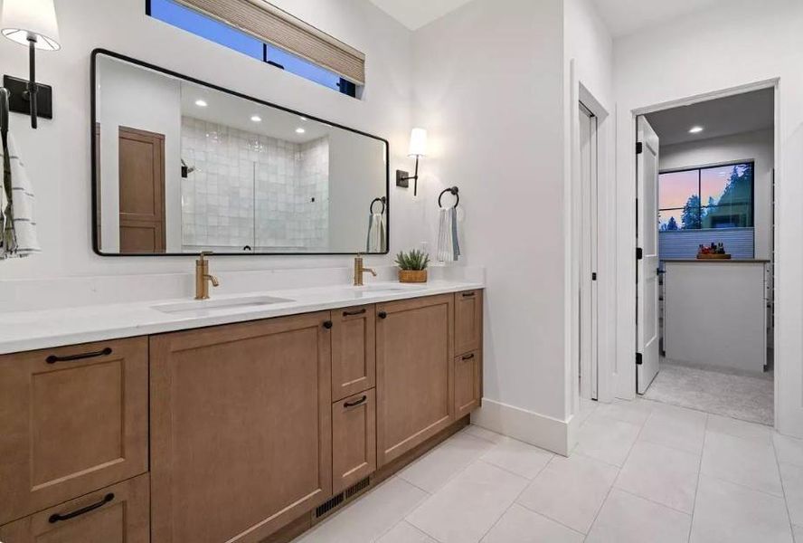 Bathroom with double vanities with Shaker Style Stained Cabinets with Transom Window above and Decorative Scones