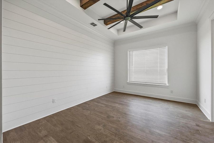 Spare room with hardwood / wood-style floors, a raised ceiling, beamed ceiling, and ceiling fan