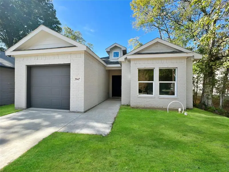 Ranch-style house featuring brick siding, a front lawn, driveway, and an attached garage