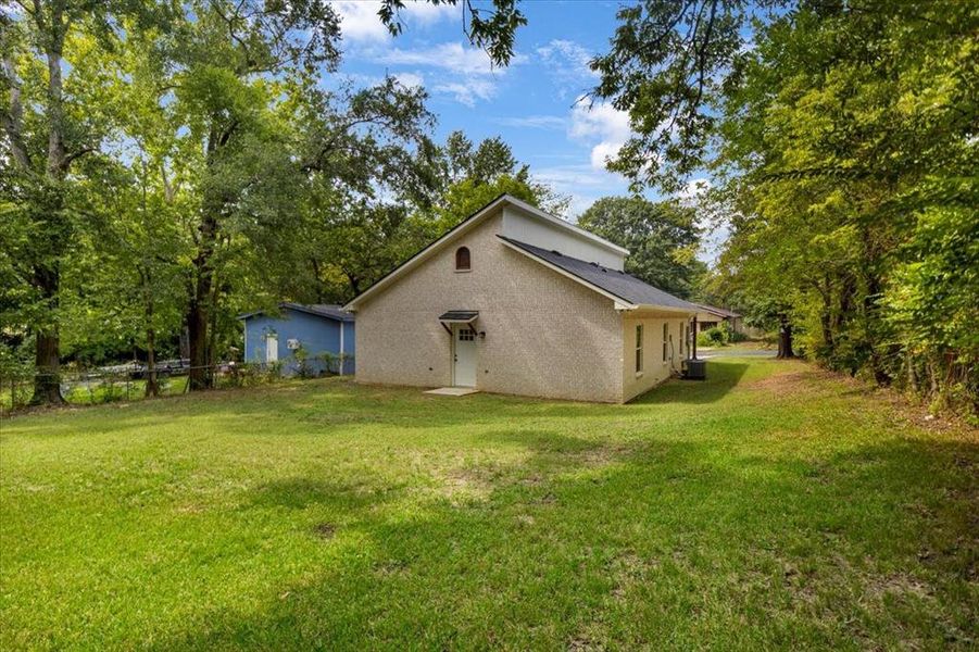 View of home's exterior featuring view of wooded area