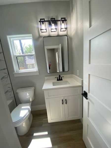 A well-lit bathroom with a bright window, sleek vanity, and modern fixtures. A well-lit bathroom with a bright window, sleek vanity, and modern fixtures.
