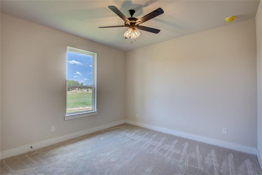 Carpeted spare room featuring ceiling fan