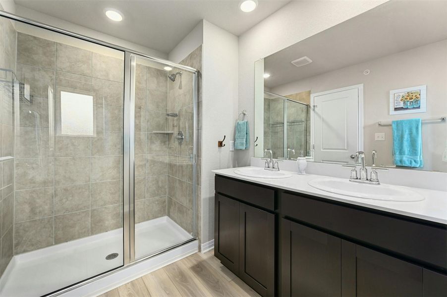 Bathroom featuring wood-type flooring, an enclosed shower, and vanity