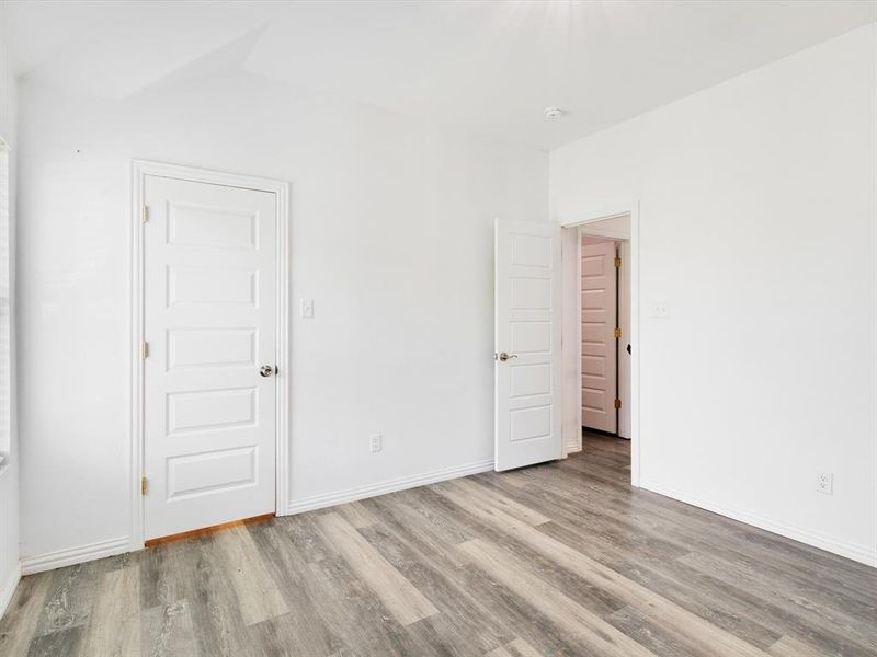 Light-filled room featuring wood-finish flooring and crisp white walls