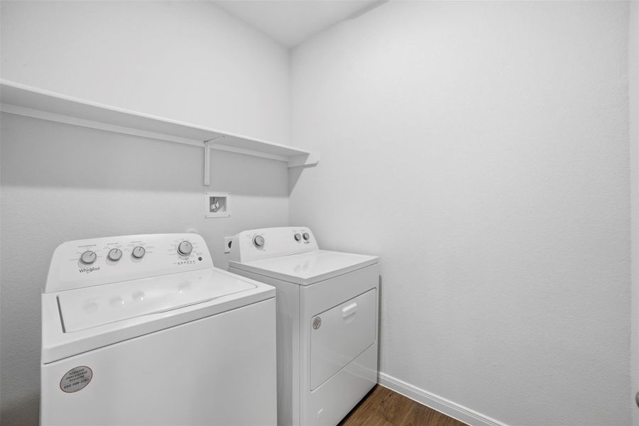 Laundry area featuring dark wood-style flooring and washing machine and clothes dryer Laundry area featuring dark wood-style flooring and washing machine and clothes dryer