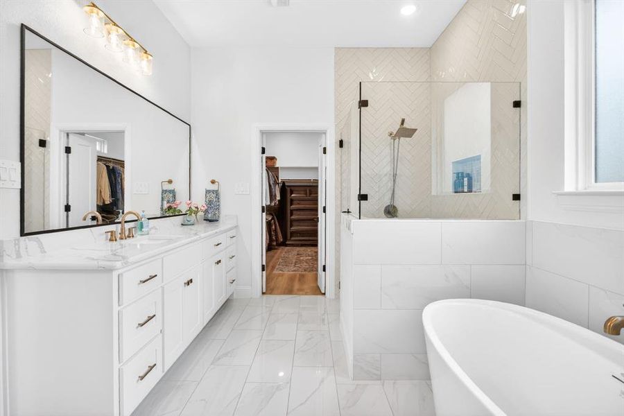 Full bath featuring a spacious closet, vanity, a tile shower, a freestanding bath, and tile walls Full bath featuring a spacious closet, vanity, a tile shower, a freestanding bath, and tile walls