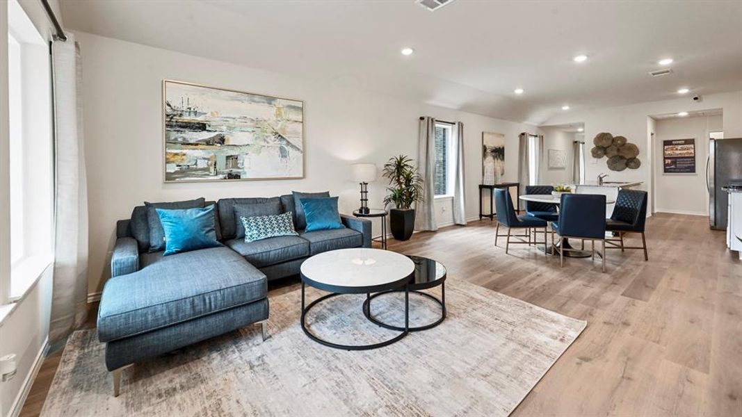 Living area featuring recessed lighting, light wood-type flooring, and lofted ceiling Living area featuring recessed lighting, light wood-type flooring, and lofted ceiling