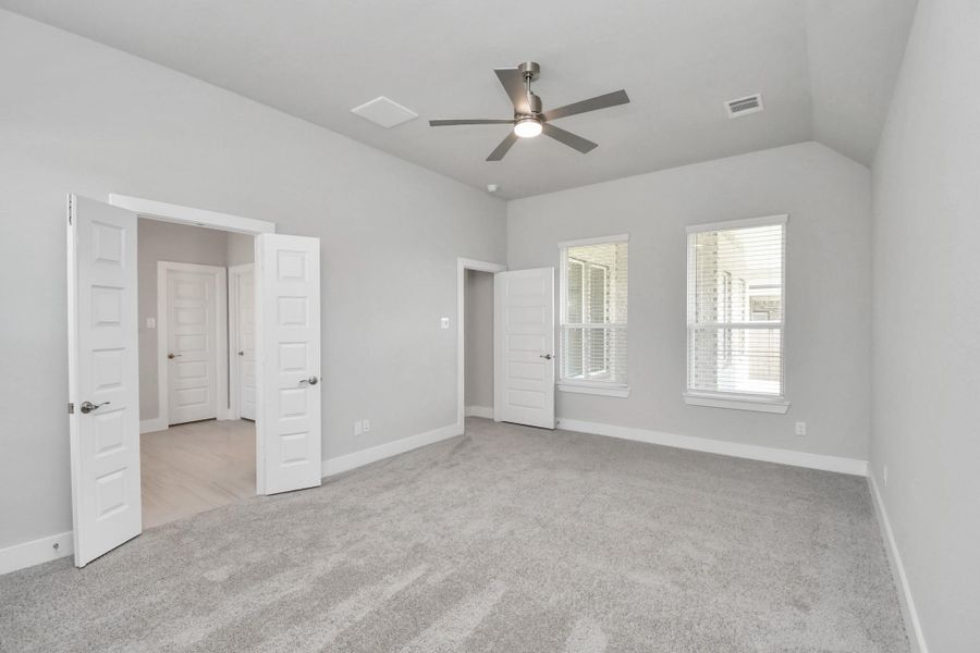 Escape to tranquility in this spacious primary room, adorned with plush carpeting and bathed in the soothing hues of warm paint colors, creating a cozy retreat for relaxation. Sample photo of completed home with similar floor plan. Actual colors and selections may vary.